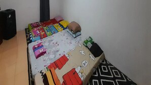 A room with a bed, a window with curtains, a wall-mounted light switch, and a power outlet. - Cozzy Darmaga Palayangan Pangalengan (pangalengan)