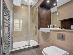 A modern bathroom with a glass-enclosed shower, a white sink, and a toilet. - Canary Heights 2bed by Interhome (London)