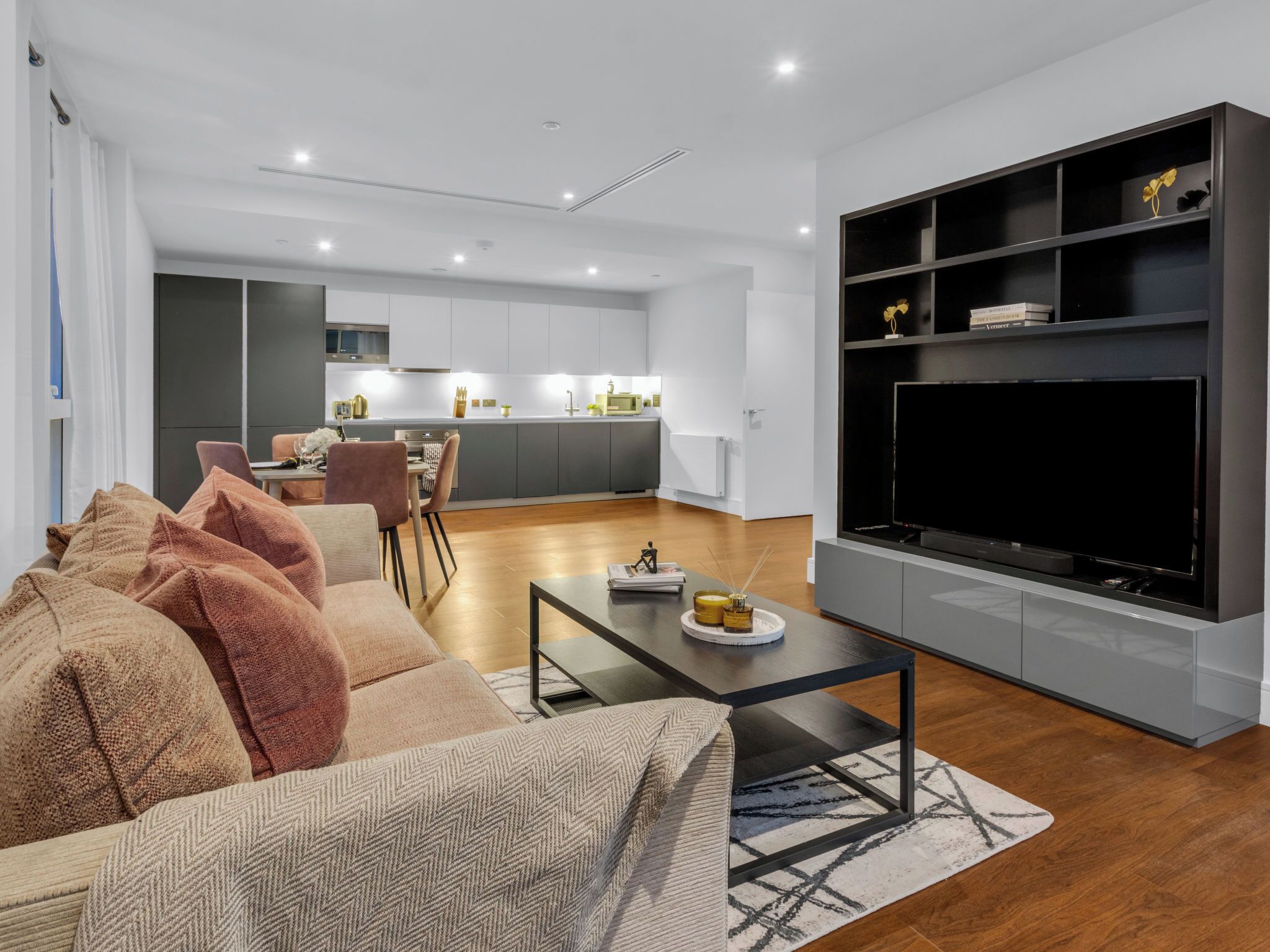 A modern living room with a sofa, coffee table, and a TV.