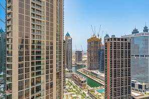 Ein Hochhaus mit modernem Design, ein Fluss, der sich hindurchzieht, und weitere Hochhäuser im Hintergrund.