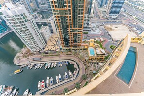 Ein Hochhaus mit einer Marina, Booten und einem Schwimmbad.