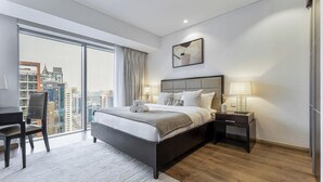 Una camera d'albergo moderna con un letto grande, una scrivania e vista sulla città.