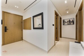Ein Flur mit Holztüren, einem Spiegel und einem Stadtbild an der Wand.