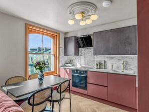A modern kitchen with a built-in oven, a sink, and a window with a view of buildings. - London West Retreat 2 by Interhome (London West End)