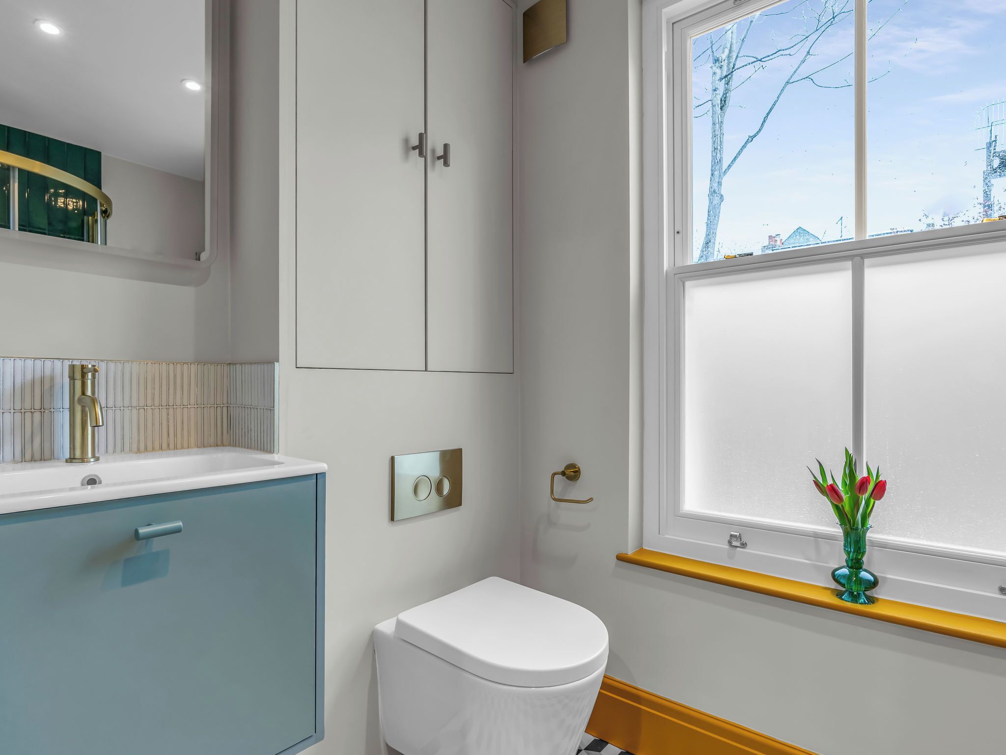 Ein Badezimmer mit Toilette, Waschbecken, einem Fenster mit Blick und einem Handtuchhalter.
