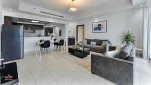 En moderne stue med sofa, sofabord og spiseplads.