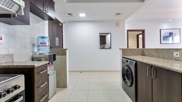 A modern kitchen with a built-in oven, a water dispenser, and a washing machine.
