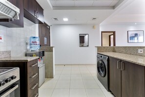 A modern kitchen with a built-in oven, a water dispenser, and a washing machine.