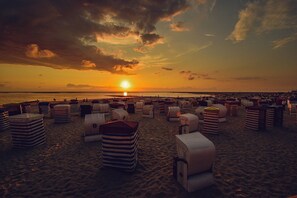 Una playa con hileras de sillas y sombrillas a rayas.