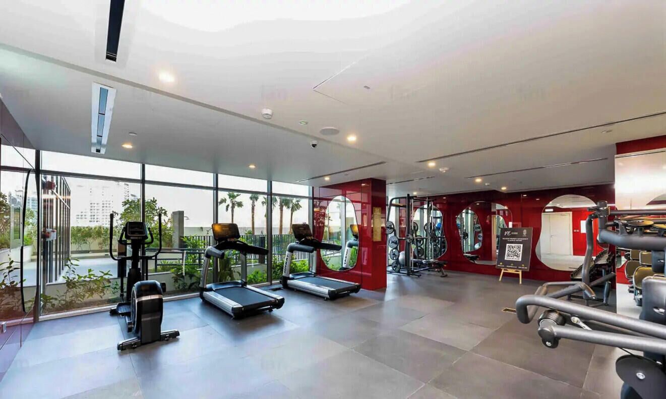 A modern gym with treadmills, exercise bikes, and weight machines.