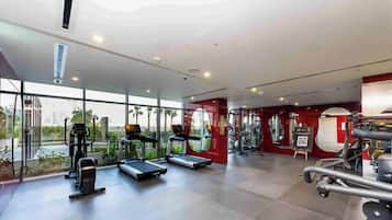 A modern gym with treadmills, exercise bikes, and weight machines.
