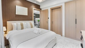 Een hotelkamer met een groot bed, houten paneelwanden, een spiegel en een kledingkast.