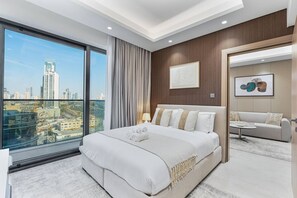 Une chambre d’hôtel avec un grand lit, un canapé, une petite table et une vue sur le paysage urbain.