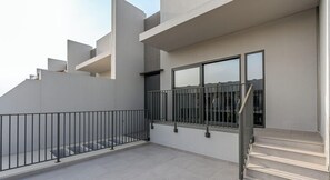 A modern building with a staircase leading to a balcony with a metal railing. - Spacious | 4 Bed Villa | Private Pool | Meydan (Dubai)