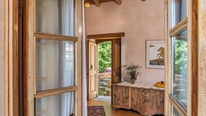 Ein rustikales Interieur mit Holzbalken, einer Steinwand und einem Holzschrank mit einer Vase.
