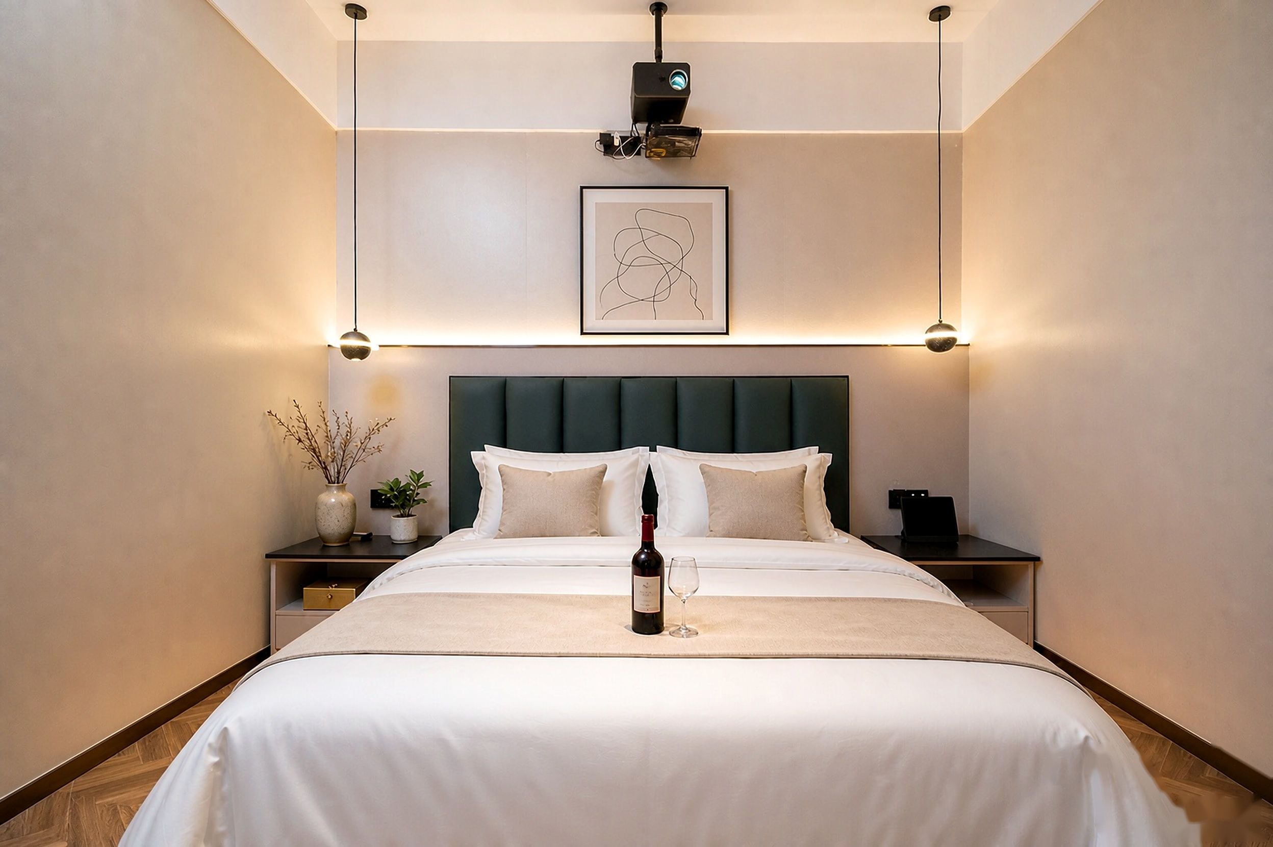 Habitación de hotel con una cama grande, una mesita de noche con una botella de vino, una obra de arte enmarcada sobre la cama y una lámpara moderna.