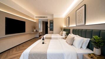 A hotel room with two beds, a flat-screen TV, and a minibar.