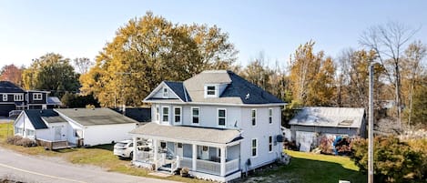 A two-story house with a porch, a garage, and a small shed.