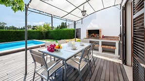 A covered outdoor dining area with a pool, a grill, and a view of the greenery. - Villa Provenza with Private Pool, Terrace, A/C & Wi-Fi (Las Palmeras)