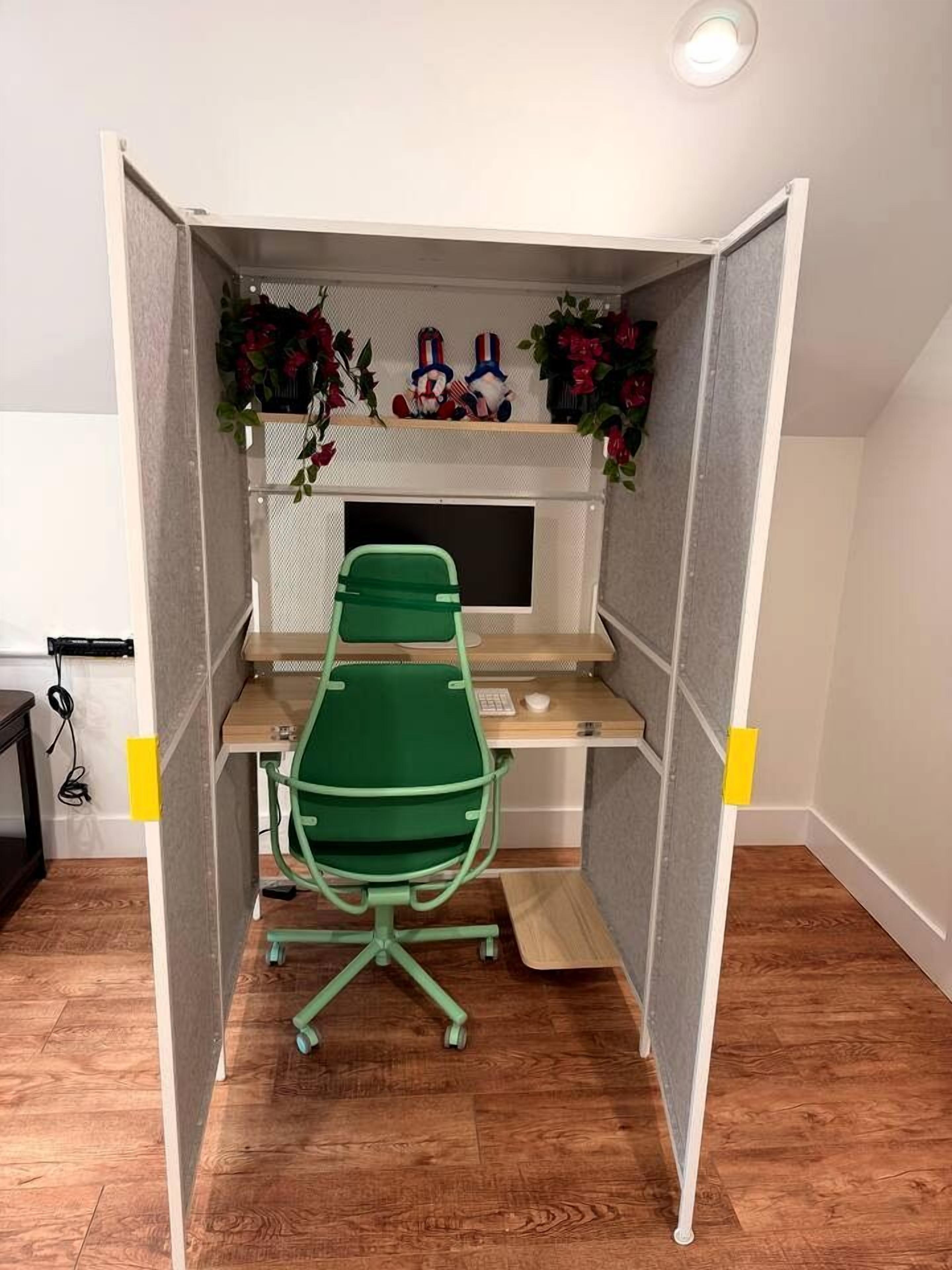 Un espace de bureau divisé comprenant une chaise verte, un bureau et un écran d’ordinateur.