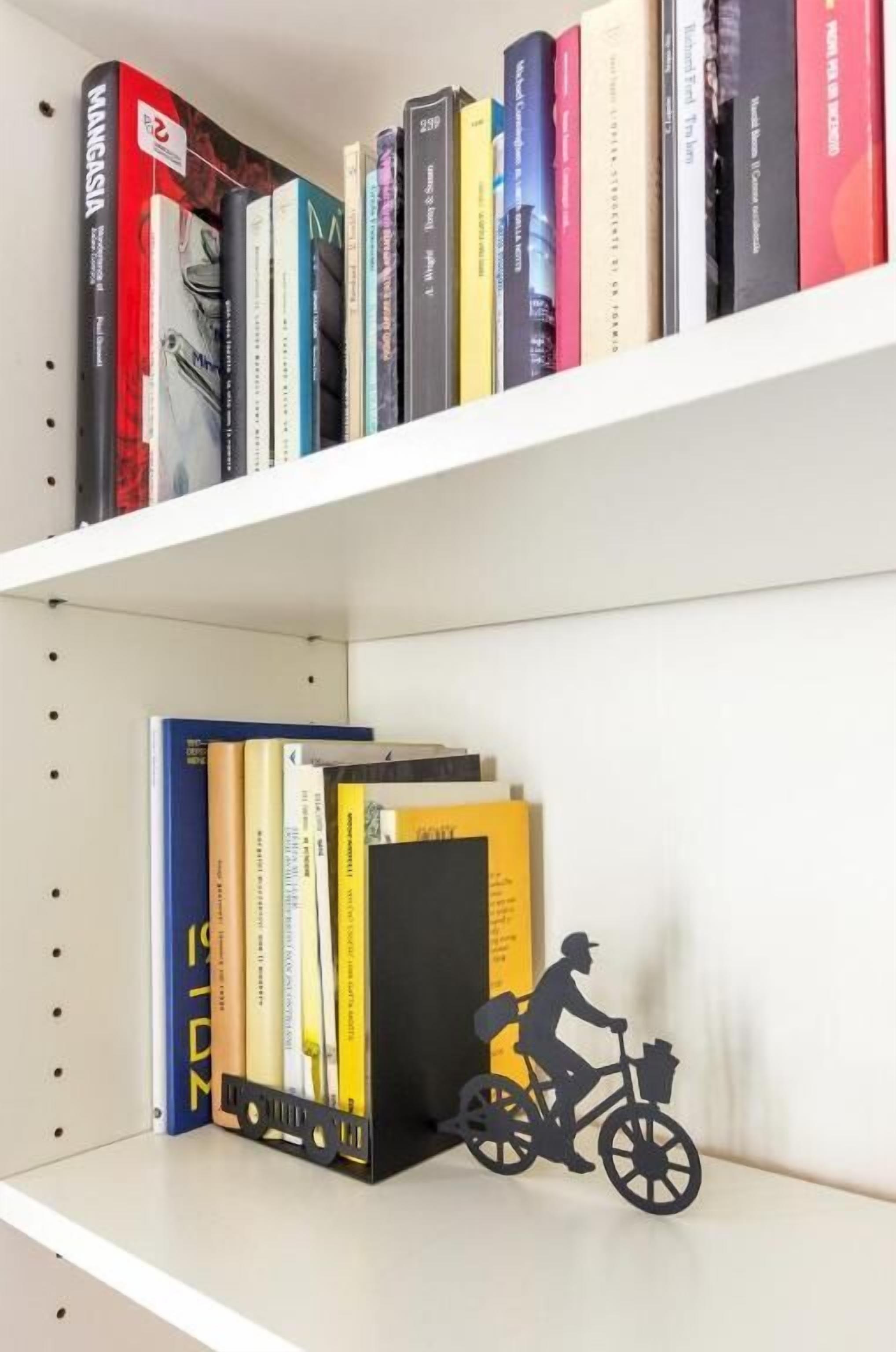 A bookshelf with books and a decorative bicycle figure.