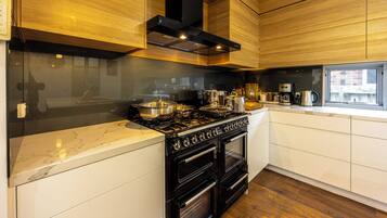 A modern kitchen with a gas stove, oven, and a coffee maker on the counter.