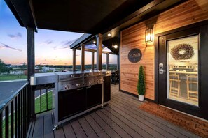 Ein Grill auf einer Terrassenfläche mit Blick auf die Landschaft.