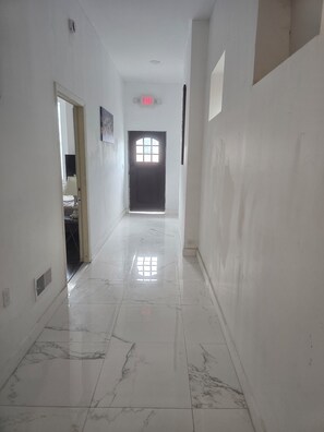 A hallway with a marble floor, a door with a window, and a ceiling light. - Over-The-Rhine 4-bedroom 3 bathroom house with off street parking in Cincinnati (Cincinnati)