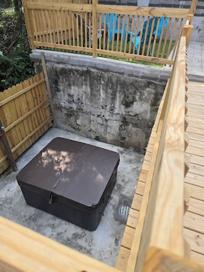 A compact outdoor space with a wooden fence, a concrete wall, and a black storage box. - Over-The-Rhine 4-bedroom 3 bathroom house with off street parking in Cincinnati (Cincinnati)
