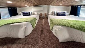 Ein Zimmer mit zwei Betten, einer Holzbalkendecke und einem Teppichboden.