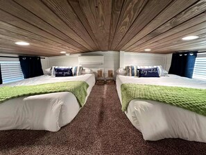 A room with two beds, a wooden ceiling, and a carpeted floor. - Charming Tiny Home Hideaway with Resort Pool Near Fredericksburg, TX (Fredericksburg)