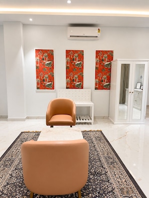 Un vestíbul d'hotel modern amb zona de seients, una catifa amb disseny i obra decorativa a les parets.