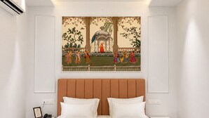 A modern bedroom with a large bed, a headboard, a nightstand, and a wall-mounted artwork. - Mijmaan Luxury Villa Udaipur (Udaipur)