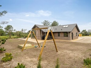 Una casa moderna con un columpio en el jardín.