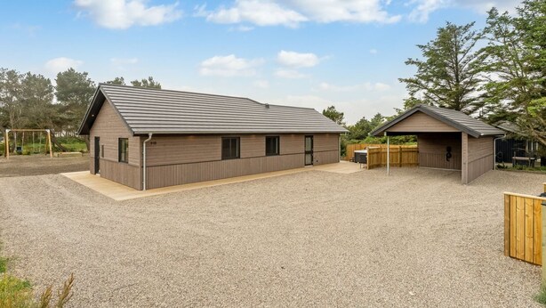A modern building with a sloped roof, a covered area, and a gravel driveway. - "Merita" - 600m from the sea by Interhome (Thisted)