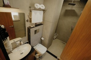 Un baño con lavamanos, inodoro y ducha.