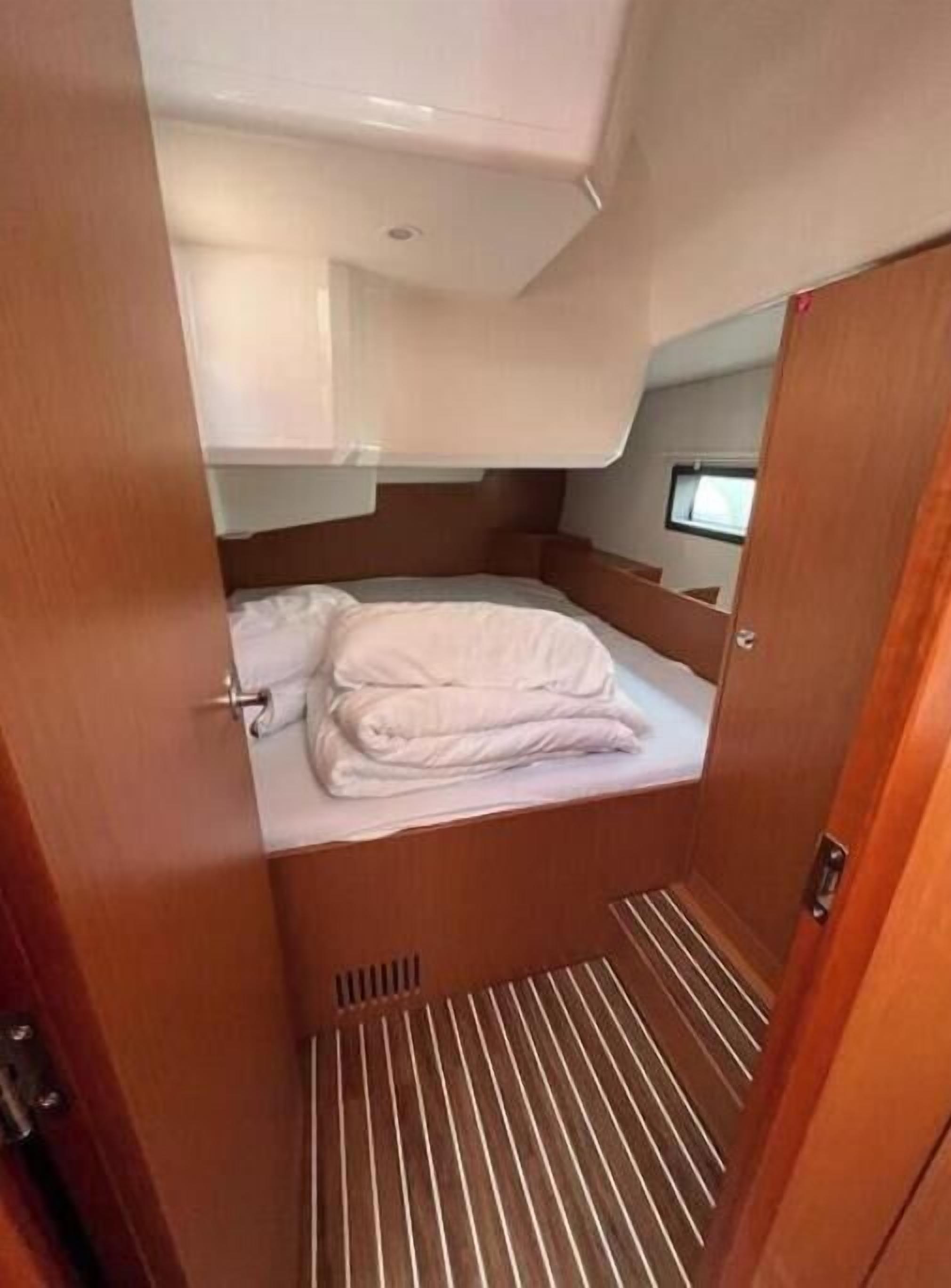 Um compartimento pequeno e fechado, com uma cama, uma janelinha e uma porta.