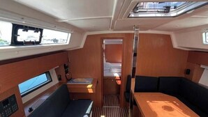 Un intérieur compact comprenant un coin salon, une petite table et un panneau de commande.