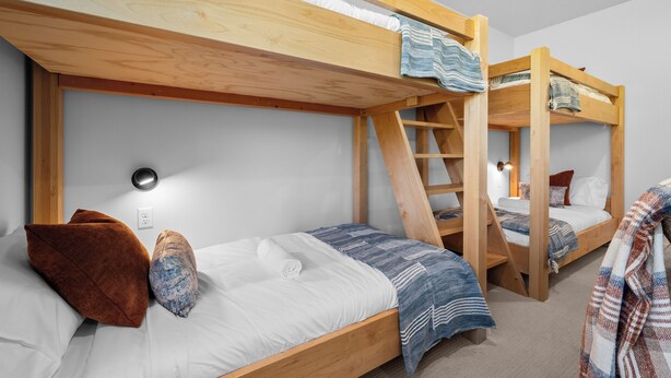 Ein Schlafzimmer mit Stockbett, einer Sprossenleiter, einer Wandsteckdose und einer Steckdose.