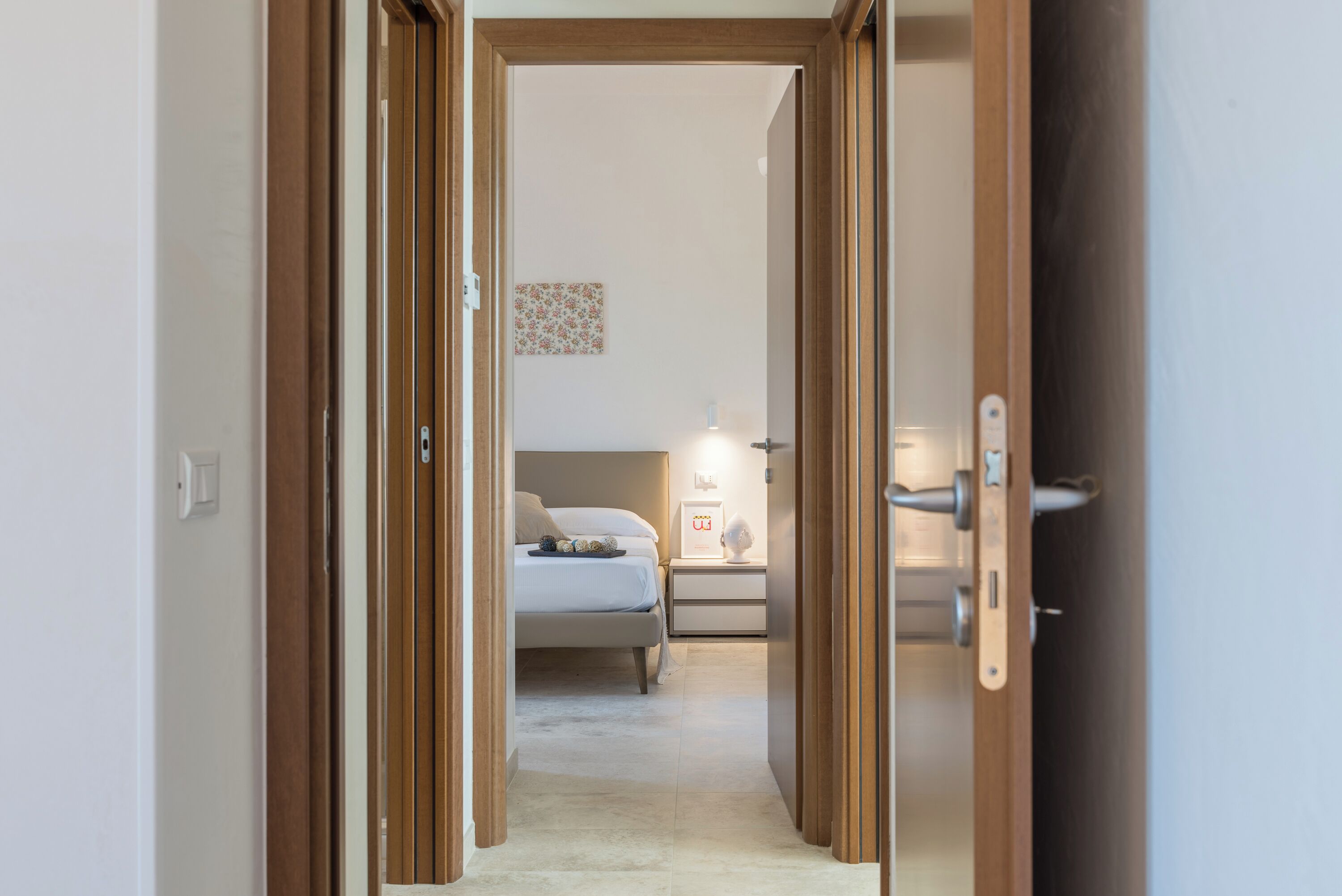 Ein Schlafzimmer mit Bett, Nachttisch und einer Wandleuchte.