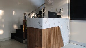 Una escalera moderna con detalles de madera y una pared de acento de mármol.