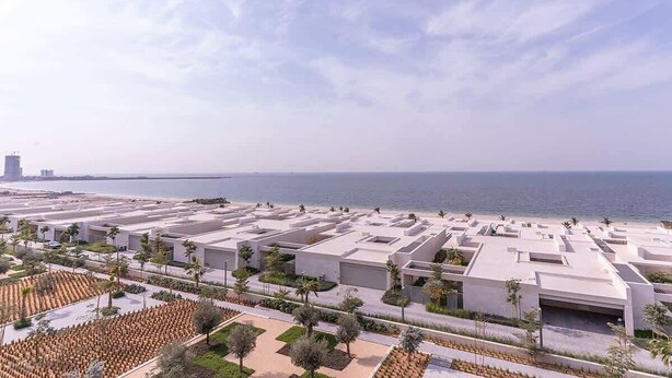 Un hôtel situé sur la côte, doté d’une architecture moderne, offrant une vue sur la plage et disposant d’un parking.
