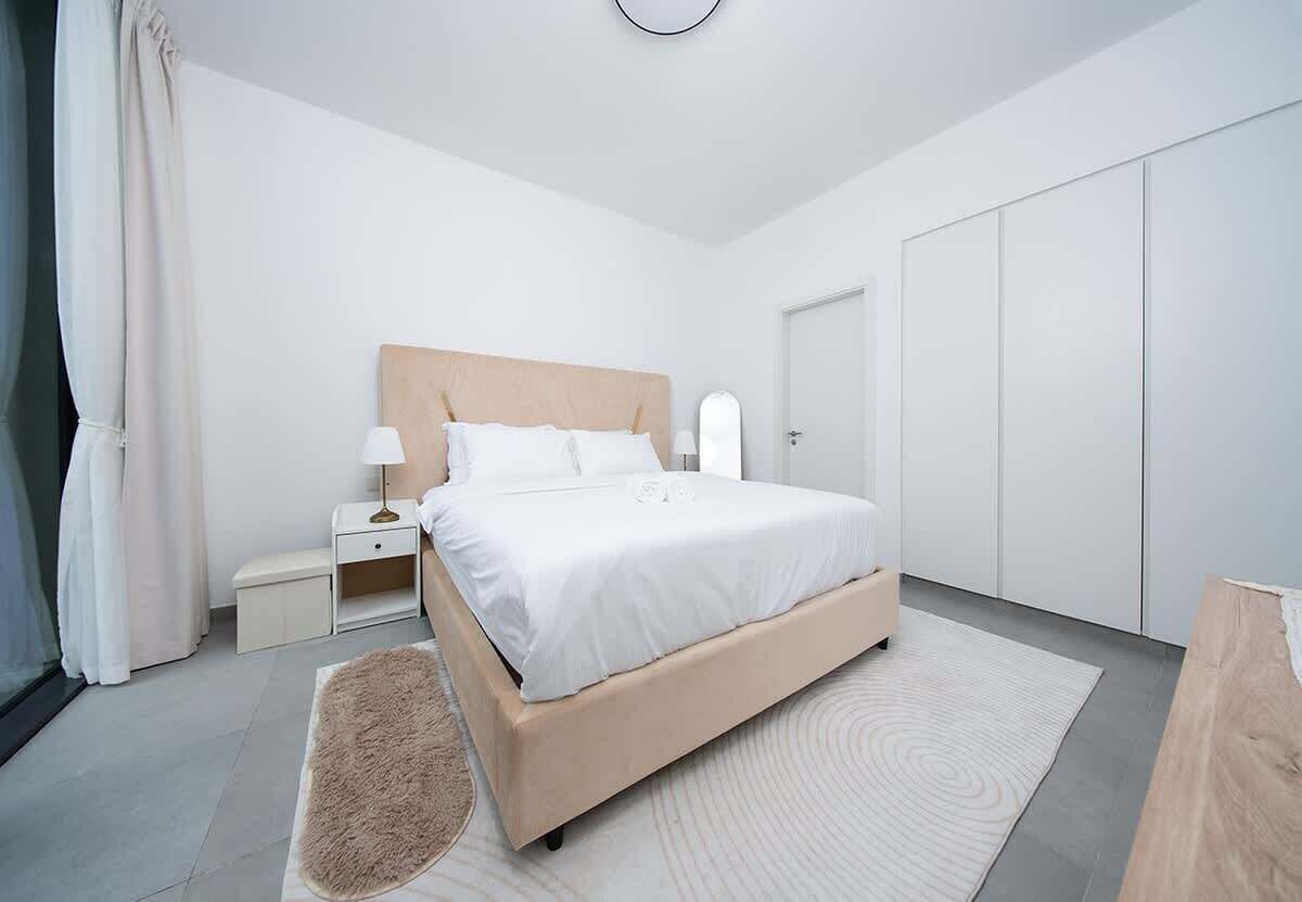 Une chambre à coucher moderne avec un lit, une table de chevet et une armoire.