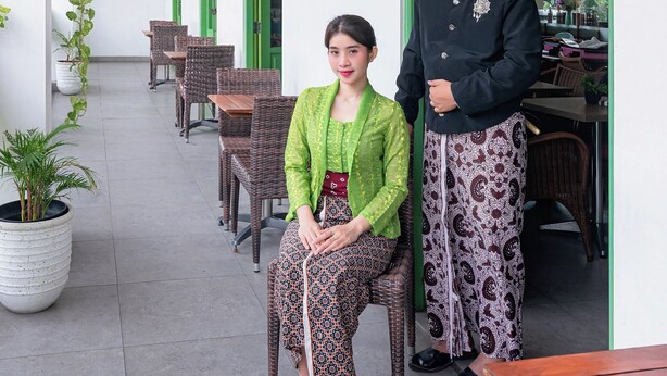 A covered outdoor seating area with wicker furniture and potted plants. - d'primahotel Malioboro Yogyakarta (Yogyakarta)