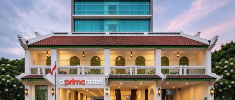 Un hotel que combina un piso superior moderno con un piso inferior de estilo tradicional, destacando un cartel con la inscripción 'd'prima hotel'.