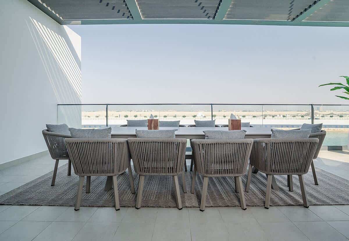 A balcony with a table and chairs, offering a view of a distant landscape.