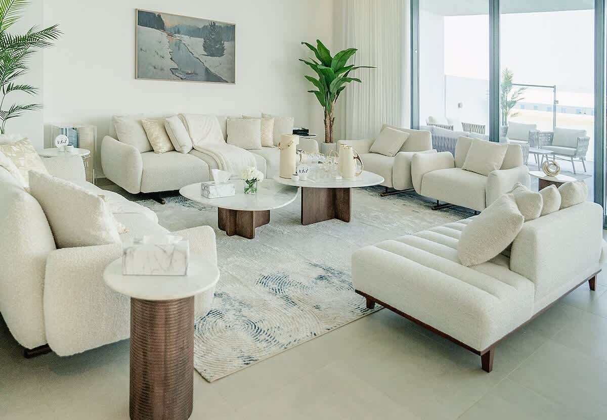 A modern living room with a sofa set, coffee table, and a large window providing a view.