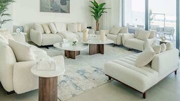 A modern living room with a sofa set, coffee table, and a large window providing a view.