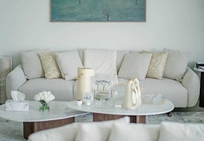 A living room with a sofa, a coffee table, and a painting on the wall.