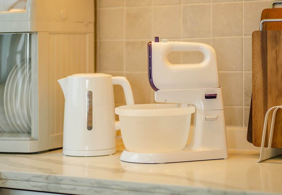 A kitchen with a coffee maker, a kettle, and a microwave.